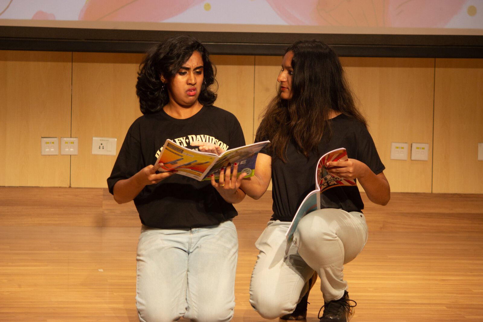 2 students doing drama with book