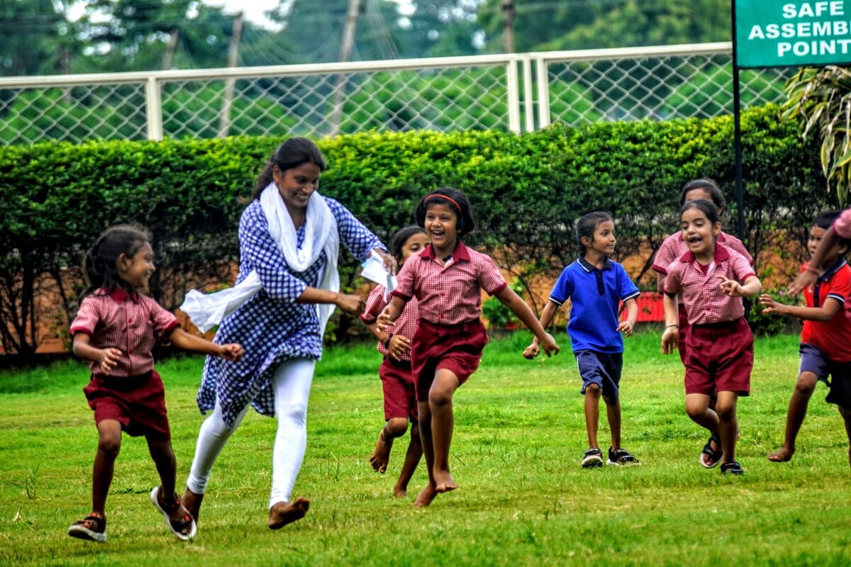 APS Dhamtari students playing with teacher