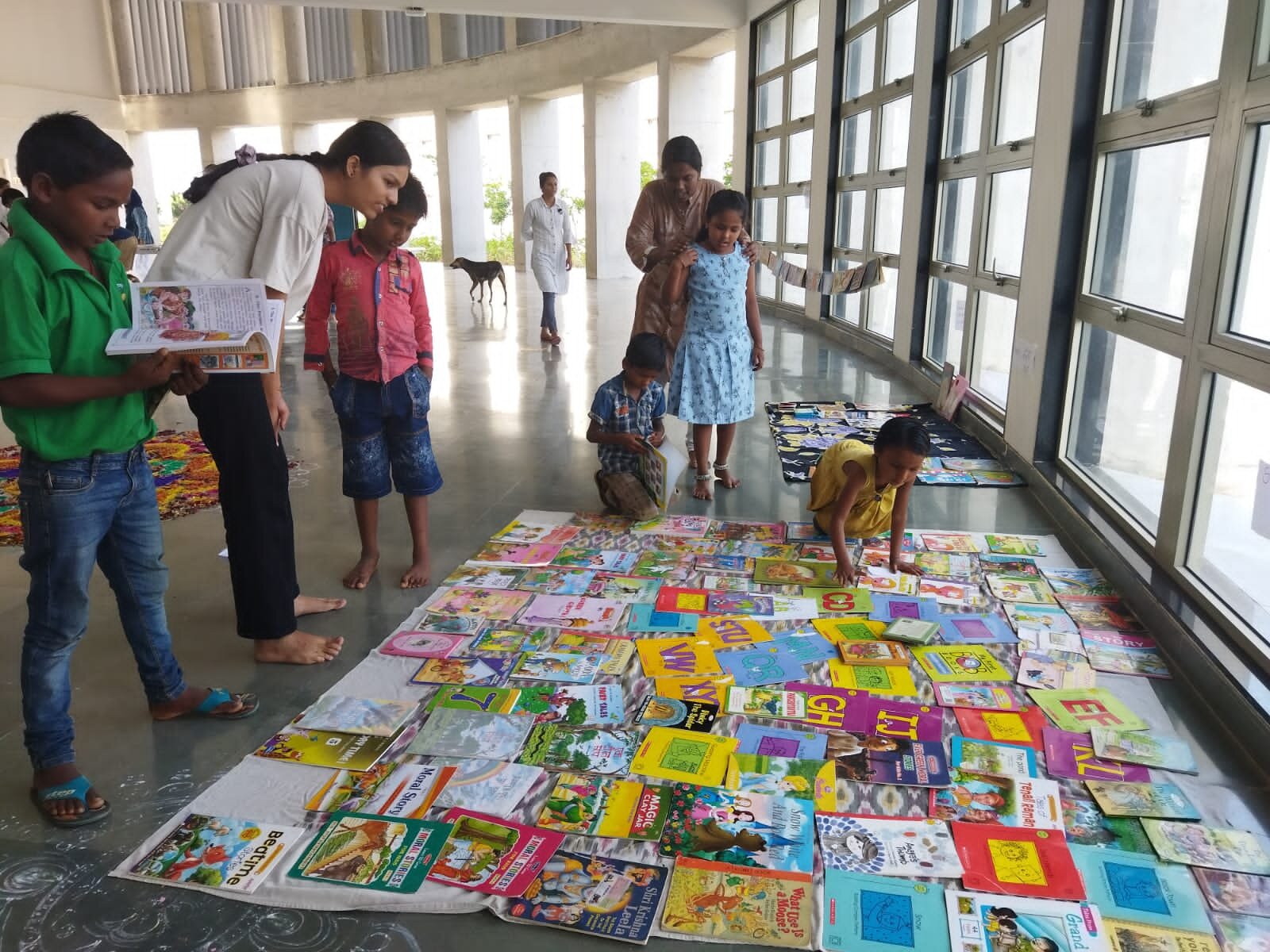 children in book exhibition with university students