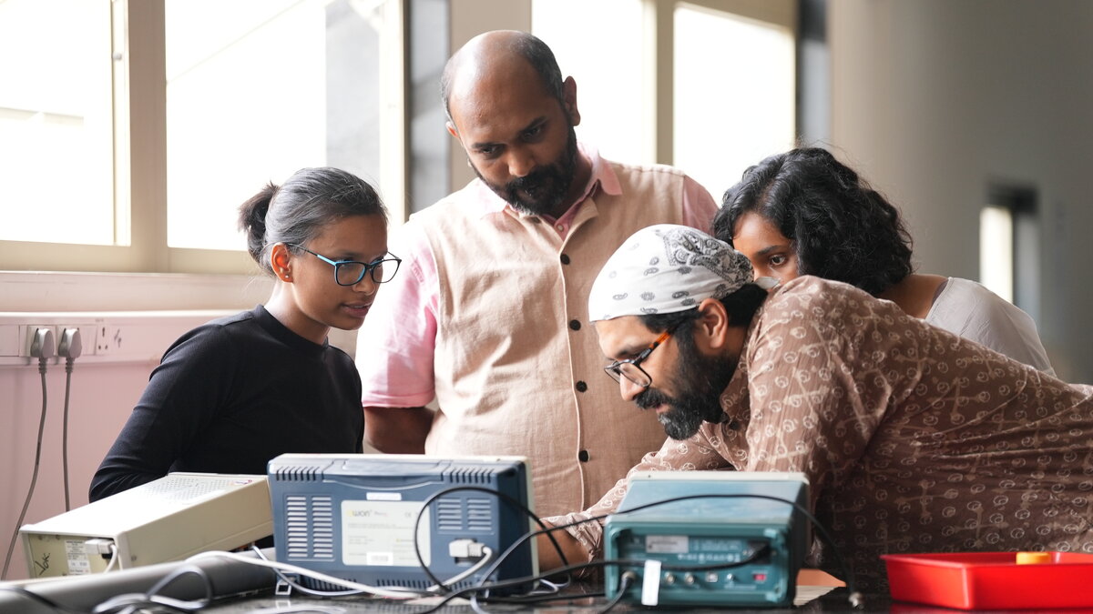 Students in physics lab with faculty
